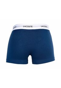 Granatowe bokserki wykonane z miękkiej bawełny z białą elastyczną gumką z nadrukowanym czarnym logo "LACOSTE".