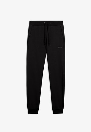 Pantaloni tuta neri a sigaretta con vita elastica, cordino, tasche laterali e piccolo logo sulla coscia destra.