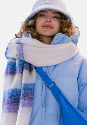 Light blue puffer jacket, white scarf with multicolored stripes, and a blue crossbody bag. Soft textures and vibrant patterns.