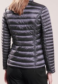 Dunkelgraue Puffjacke mit einem gesteppte Muster, featuring einem hohen Kragen und slim-fit. Hergestellt aus glänzendem, leichtem Material.