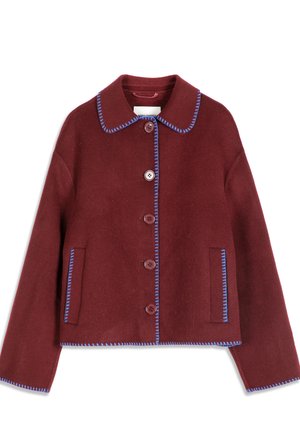 Veste boutonnée couleur marron avec surpiqûres bleues, deux poches avant et un large col, présentée sur fond blanc.