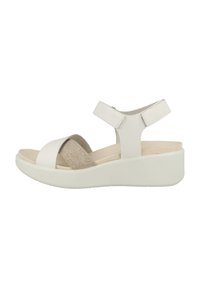 Sandales compensées blanches avec un design bicolore, comprenant une lanière en cuir lisse et une lanière en tissu texturé. Lanières de cheville ajustables pour un bon maintien.
