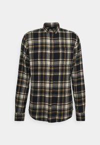 Camisa de franela con un patrón de cuadros en blanco, negro y amarillo, cuello abotonado, mangas largas y un bolsillo en el lado izquierdo del pecho.