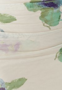 Kvetinová tkanina na šaty v jemnej krémovej farbe, s motívom zelených a purpurových listov, ľahkou textúrou tkaniny a nariaseným dizajnom pre tvar.