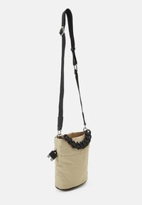 Borsa a tracolla beige trapuntata con manico superiore intrecciato nero e tracolla regolabile. Presenta hardware in argento e un attacco USB per maggiore comodità.