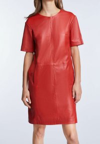 Robe en cuir rouge à manches courtes, col rond et coupe décontractée. Présente des coutures visibles et des poches sur les côtés. Texture lisse.