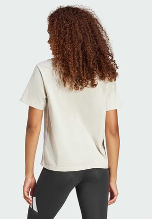 Korte mouw, romige t-shirt gemaakt van katoen, met een relaxte pasvorm en een gladde textuur, gecombineerd met zwarte leggings.