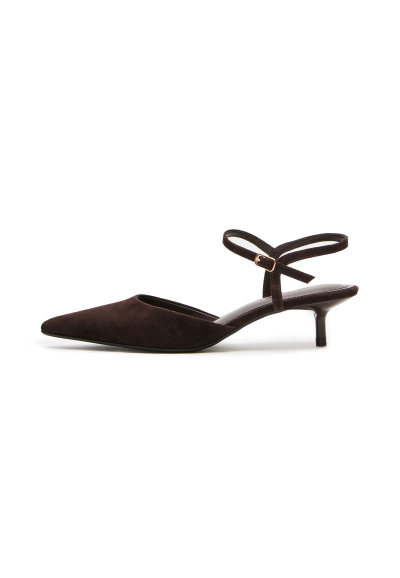 Décolleté in camoscio marrone con punta affusolata, sottile cinturino alla caviglia e tacco basso. Presenta una texture liscia e un design minimalista.