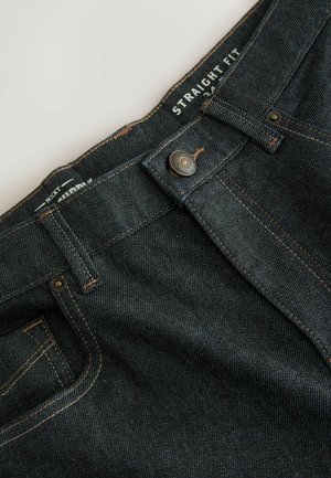 Traperice ravnog kroja u tamnoplavoj boji, s glatkom teksturom, kontrastnim zlatnim šavovima i zatvaračem na metalni gumb.