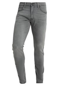 Šedé džíny z denimu s úzkým střihem, pěti kapsami a klasickým zipem. Mají jemné vyblednutí a hladkou texturu.