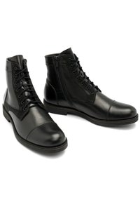 Czarne skórzane botki za kostkę o gładkim wykończeniu, z wiązaniem z przodu, bocznym zamkiem błyskawicznym oraz kontrastowym zamszowym panelem. Okrągły nosek i niski obcas.