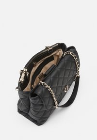 Sac à main noir matelassé avec des accents en chaîne et une fermeture éclair. L'intérieur présente une doublure beige et plusieurs compartiments pour l'organisation.