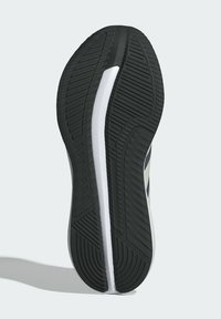 Black rubber outsole with textured grip pattern, white midsole, and navy blue accents along the side. Lightweight and curved shape.