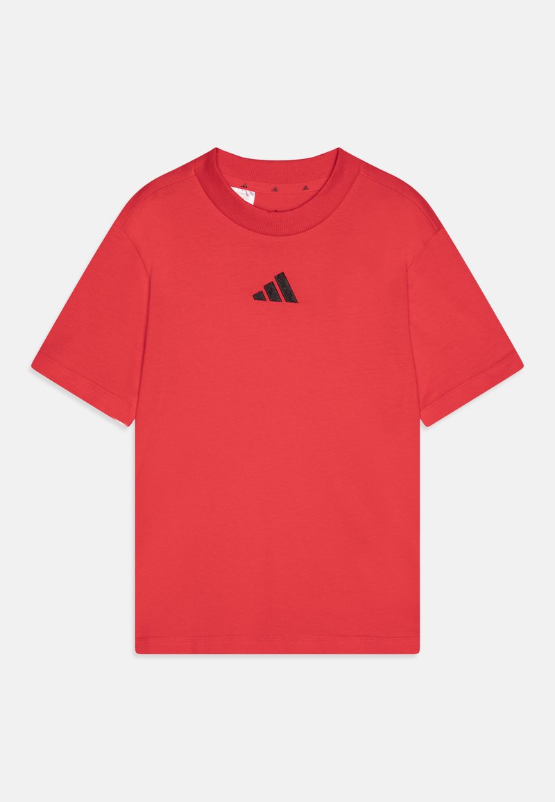 Sarkans kokvilnas T-krekls ar noapaļotu apkakli, īsām piedurknēm un mazu melnu Adidas logotipu centrā uz krūtīm. Gluda tekstūra, klasiskā piegriezne.