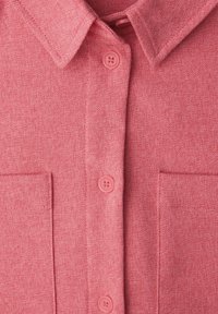 Chemise rose texturée avec col, fermeture à boutons sur le devant avec boutons assortis, et deux poches poitrine.