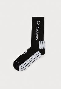 Medias hasta la rodilla negras con rayas horizontales blancas y el texto "No Problemo" en blanco, con una textura acanalada y un diseño de punta redondeada.