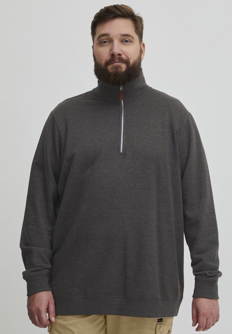 Dunkelgrauer Viertelzip-Pullover mit langen Ärmeln, aus weichem Material gefertigt. Verfügt über einen silbernen Reißverschluss und einen braunen Akzent am Saum.