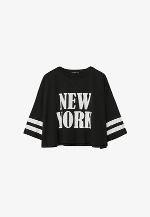 Crna skraćena majica od pamuka. Sadrži bijeli natpis "NEW YORK" i dvije bijele horizontalne pruge na rukavima. Labav kroj i široki izrez.