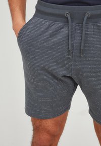 Gray shorts with a textured pattern, featuring a ribbed waistband, drawstring closure, and side pockets.