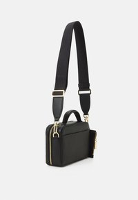 Černá kožená kabelka přes rameno s texturovaným povrchem, zlatým zipem a kováním. Má odnímatelný černý popruh a horní rukojeť.