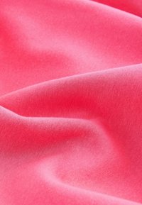Tissu rose vif, lisse et légèrement froissé, avec une texture douce et des plis délicats.