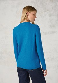Maglione blu con scollatura rotonda, maniche lunghe e una texture liscia, caratterizzato da bordi a coste e una struttura leggermente aderente.