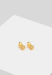 Boucles d'oreilles en forme de fleur en ton doré, avec des pétales texturés et une finition lisse et brillante. Conçues avec un support à clou pour un port sécurisé.