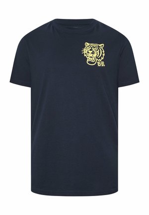 Laivastonsininen lyhythihainen t-paita, jossa on keltainen avoimen suun tiikerin pää -kuvio ja "BR"-alkuiset nimikirjaimet vasemmassa rinnassa.