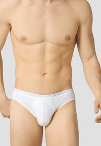 Slip bianchi realizzati in morbido cotone misto. Caratterizzati da una vestibilità aderente e una cintura elastica con il marchio "SLOGGI". Design semplice e senza cuciture.