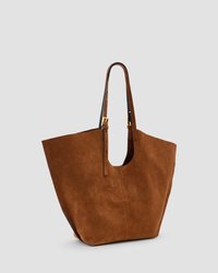Borsa a spalla in suede marrone con una ampia apertura superiore, due manici regolabili e una texture liscia. Presenta un dettagliato minimo nelle cuciture sulla parte frontale.