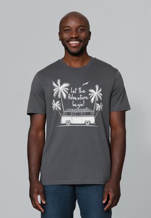 Grijze katoenen t-shirt met een witte grafische afbeelding van palmbomen en een vintage busje, met de tekst "Laat het avontuur beginnen!"
