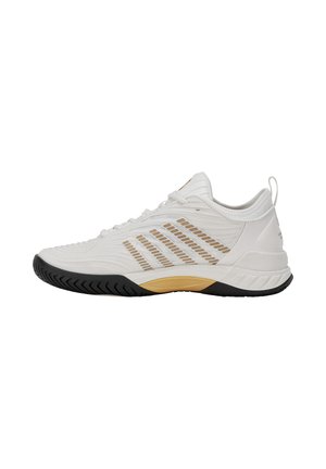 Chaussure de sport blanche avec des bandes de ventilation beiges, semelle noire et languette au talon, vue de côté sur fond blanc.
