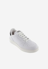 Sneaker blanche avec des détails perforés, lacets plats, un accent de talon texturé noir et un logo doré sur le côté. Semelle en caoutchouc.