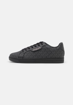 Czarne sneakersy z teksturowanym materiałem wierzchu, zdobionym wzorem z logo 'MK'. Czarne skórzane akcenty, sznurowana konstrukcja oraz gumowa podeszwa.