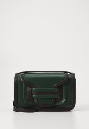 Zielona skórzana torba na ramię z czarnymi akcentami, o strukturalnym designie, z klapą zamykającą i odpinanym paskiem.