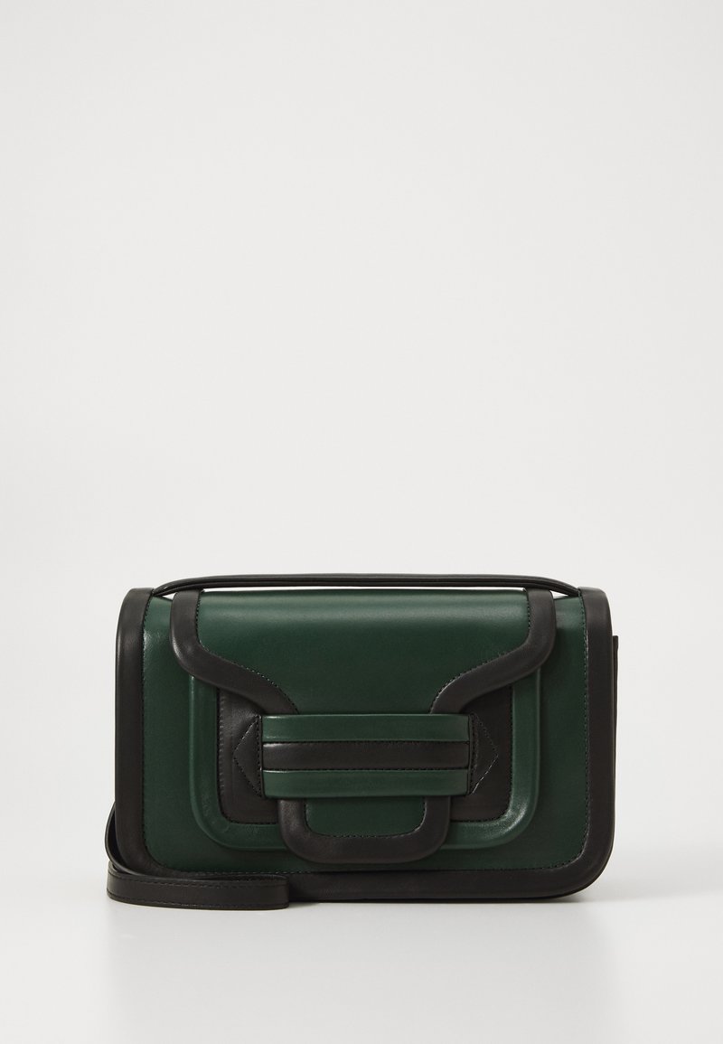 Sac à bandoulière en cuir vert avec des accents noirs, présentant un design structuré, une fermeture à rabat et une sangle détachable.