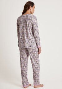 Langdurige pyjama set in een paarse paisleyprint, met roze manchetten. Gemaakt van zacht materiaal met een losse pasvorm, gedetailleerd ontwerp over het oppervlak.