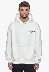 Hoodie surdimensionné blanc en tissu doux, avec une poche avant et le texte "Dropsize" en violet sur la zone du côté gauche de la poitrine.