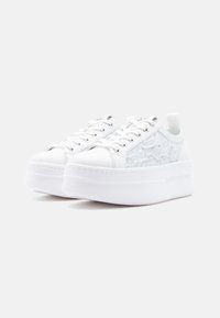 Hvite plattformsneakers med glatt skinnoverdel og mesh-sidepaneler. Rund tå, snøring og hælhempe for enkel påkledning.