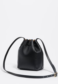 Borsa a secchiello nera in pelle con superficie testurizzata, chiusura con coulisse e tracolla regolabile con fibbia in tonalità oro.