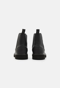 Zwarte leren enkellaarsjes met gestructureerde zijkanten, elastische panelen en aantreklussen. Rubberen zolen met lichte profiel voor grip. Minimalistisch ontwerp.