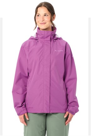 Frau trägt eine lila Vaude wasserdichte Jacke mit hohem Kragen und grüne Hose, steht und lächelt leicht zur Seite.
