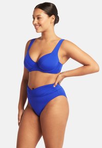 Niebieski dwuczęściowy bikini z usztywnianym stanikiem o szerokich ramiączkach i wysokim stanem majtek z marszczeniami. Gładki, elastyczny materiał.