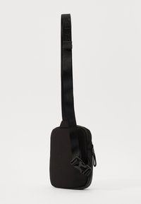 Black sling bag with a sleek rectangular shape, a textured fabric finish, zip closure, and a wide adjustable strap with a buckle.