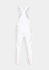 Bílé denimové pracovní kalhoty s nastavitelnými ramínky, rovnými nohavicemi, několika kapsami a volným střihem. Hladká textura s minimem švů.