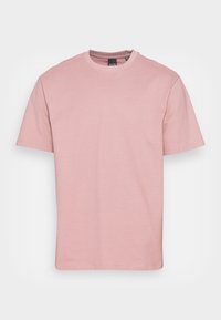 T-shirt a maniche corte e colletto tondo in morbido tessuto rosa, con una texture liscia e un design semplice e classico.