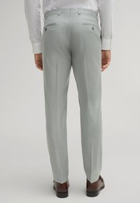 Helle graue Hose aus strukturiertem Stoff, mit schmaler Passform, zwei Gesäßtaschen mit Knöpfen und einer Bügelfalte an der Vorderseite.