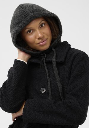 Black textured coat with a gray hood, button closure, and drawstrings. The fabric has a soft, cozy appearance.