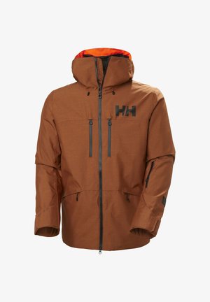 Braune isolierte Jacke mit Kapuze, ausgestattet mit schwarzen Reißverschlüssen und zwei vorderen Taschen. Enthält ein lebhaftes oranges Futter und ein Logo auf der Brust.