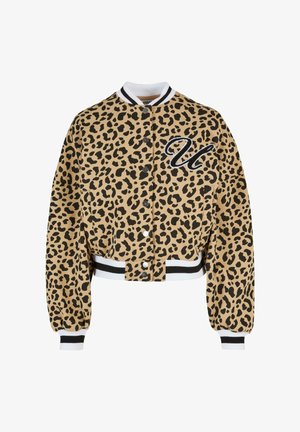 Lyhyt, beige leopardikuosiset takki mustilla pilkuilla. Ominaisuuksiin kuuluu nappikiinnitys, valko-musta raidallinen kaulus ja brodattu kirjain "U."